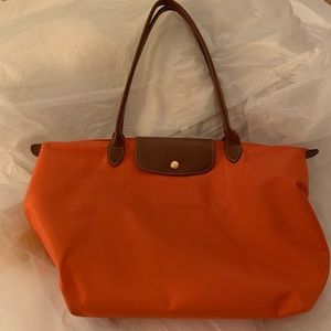 Orange Longchamps "Le Pliage" bag.